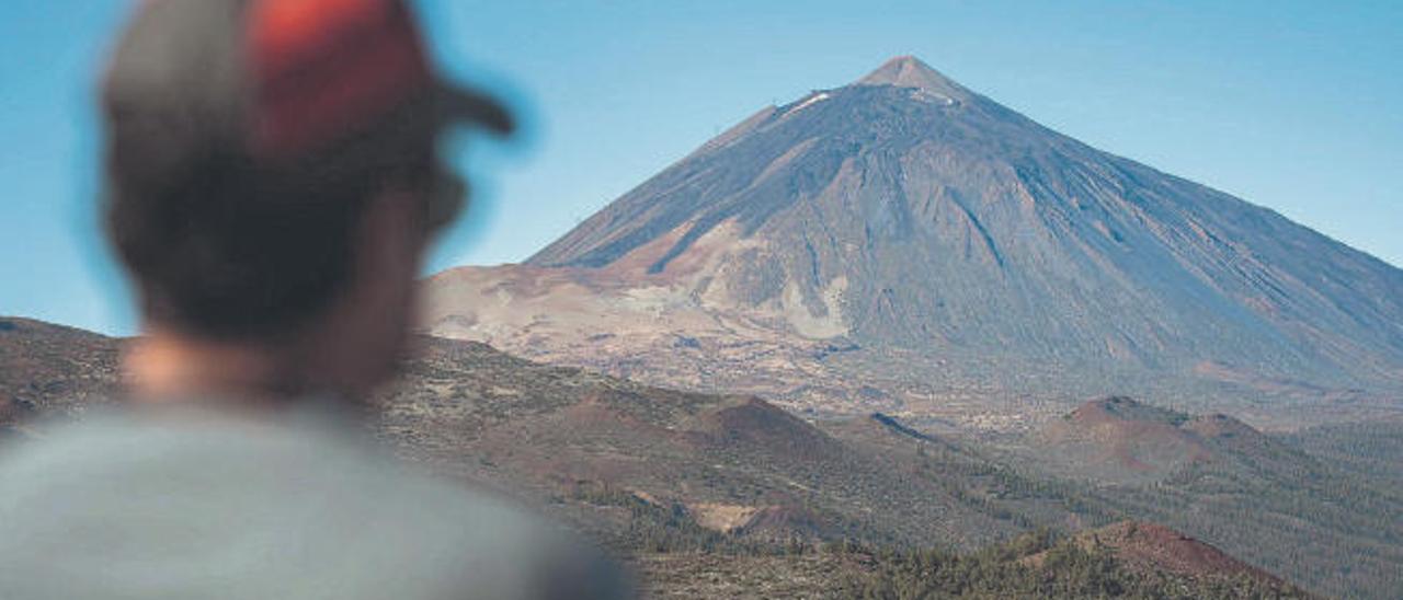 Un hombre contempla el Teide en una mañana soleada desde el Parque Nacional