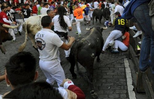 Runners fall in front of Conde de la Maza fighting bulls on Telefonica corner during the sixth running of the bulls of the San Fermin festival in Pamplona