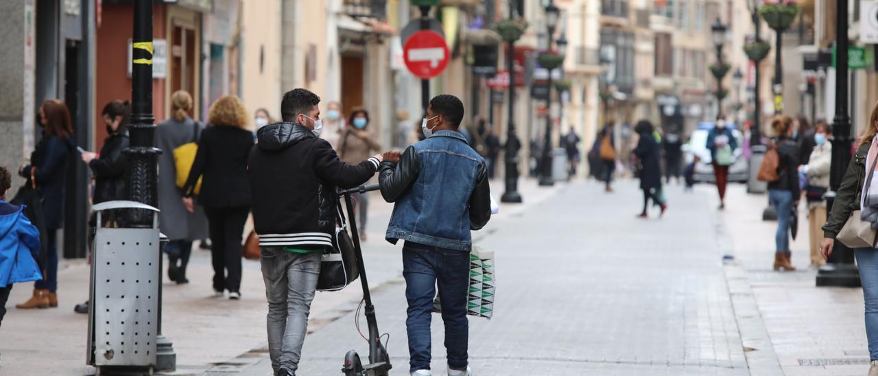 Dos personas con patinete en el centro de Castelló.