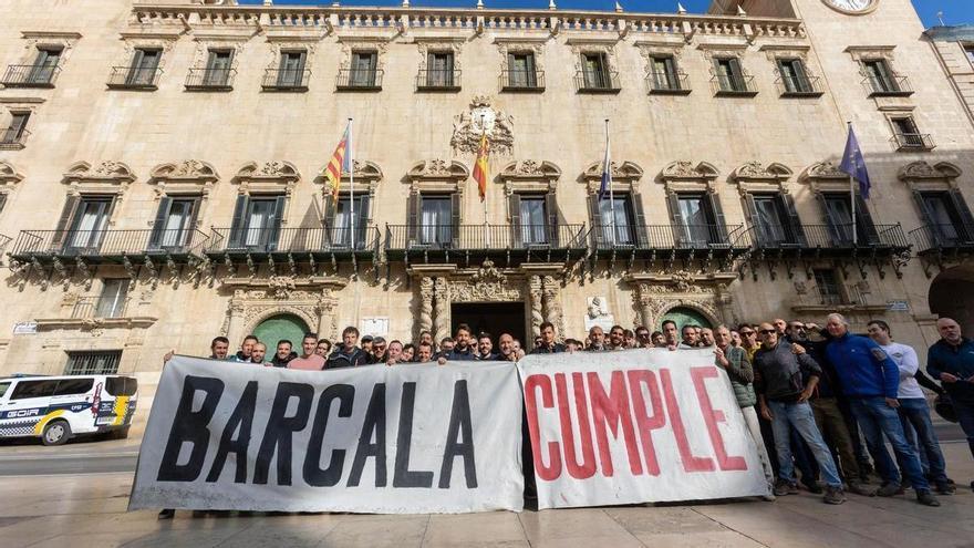 Bomberos tras una pancarta con el lema «Barcala, cumple», antes del pleno de marzo, marcado por la tensión.