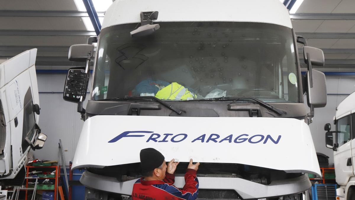 Un trabajador de Frío Aragón realiza labores de mantenimiento de un camión.