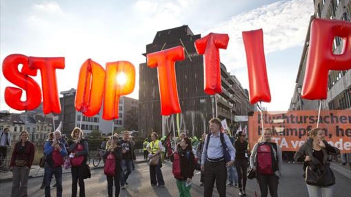 Unos manifestantes portan globos con los que piden que se pare el TTIP, ayer en Bruselas.