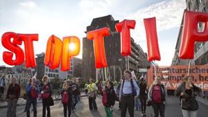 Unos manifestantes portan globos con los que piden que se pare el TTIP, en Bruselas.