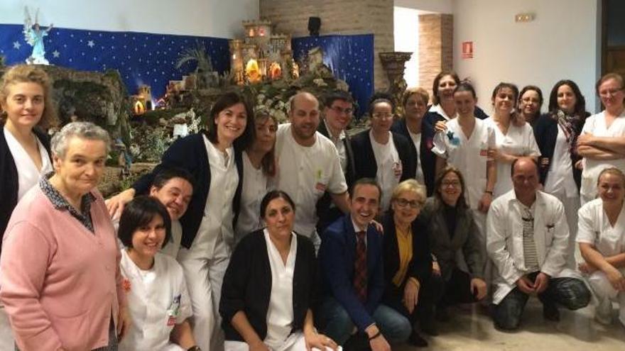 Mayte Martín Pozo posa con los trabajadores de la residencia Virgen del Canto de Toro junto al belén navideño.