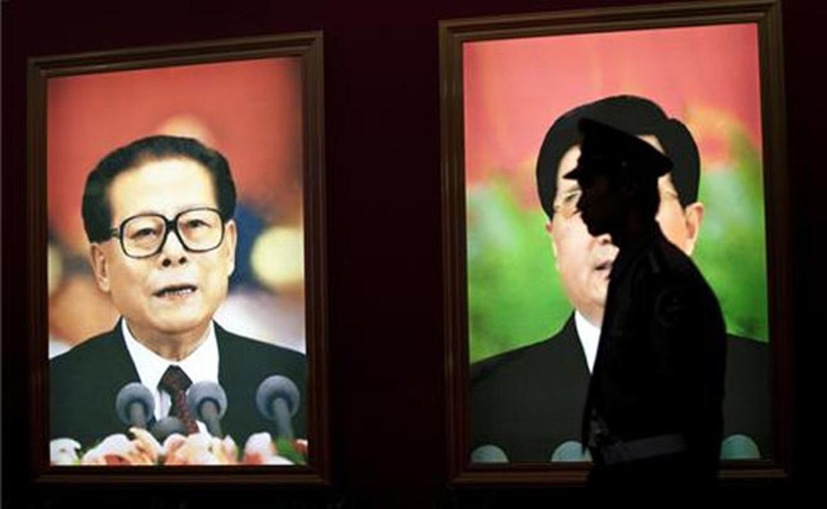 Un guàrdia de seguretat s’atura davant un retrat de l’expresident de la Xina Jiang Zemin que es mostra en una exposició commemorativa del 90è aniversari del Partit Comunista de la Xina a Pequín.