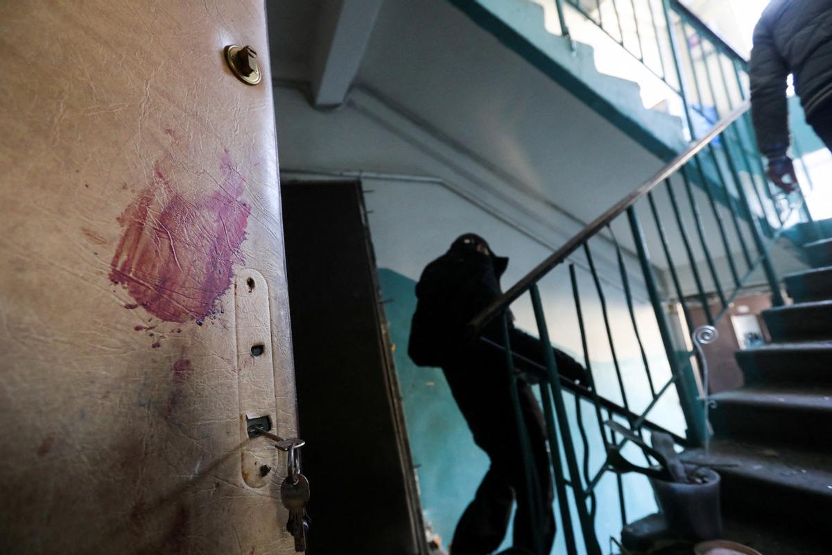 Interior de un edificio residencial de Kiev, con una mancha de sangre en una puerta, tras un bombardeo ruso.