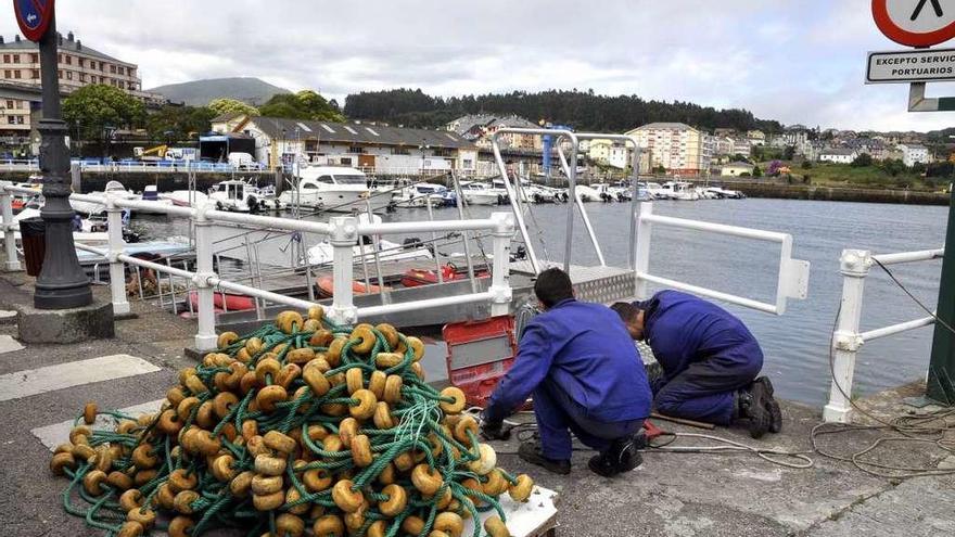 Operarios, poniendo a punto el muelle naviego para la competición de natación.