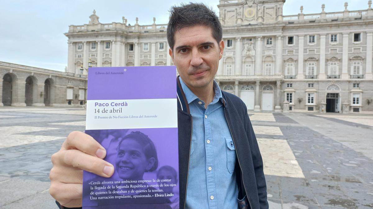 Paco Cerdà, con su libro, delante del Palacio Real de Madrid.