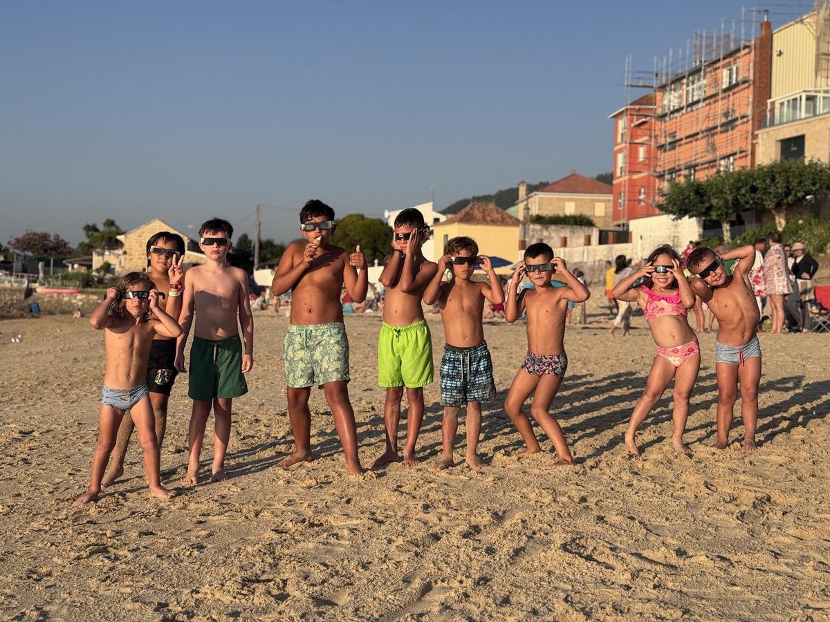 Bañistas y vecinos siguen el eclipse solar desde Loureiro. Bañistas y vecinos siguen el eclipse solar desde Loureiro.