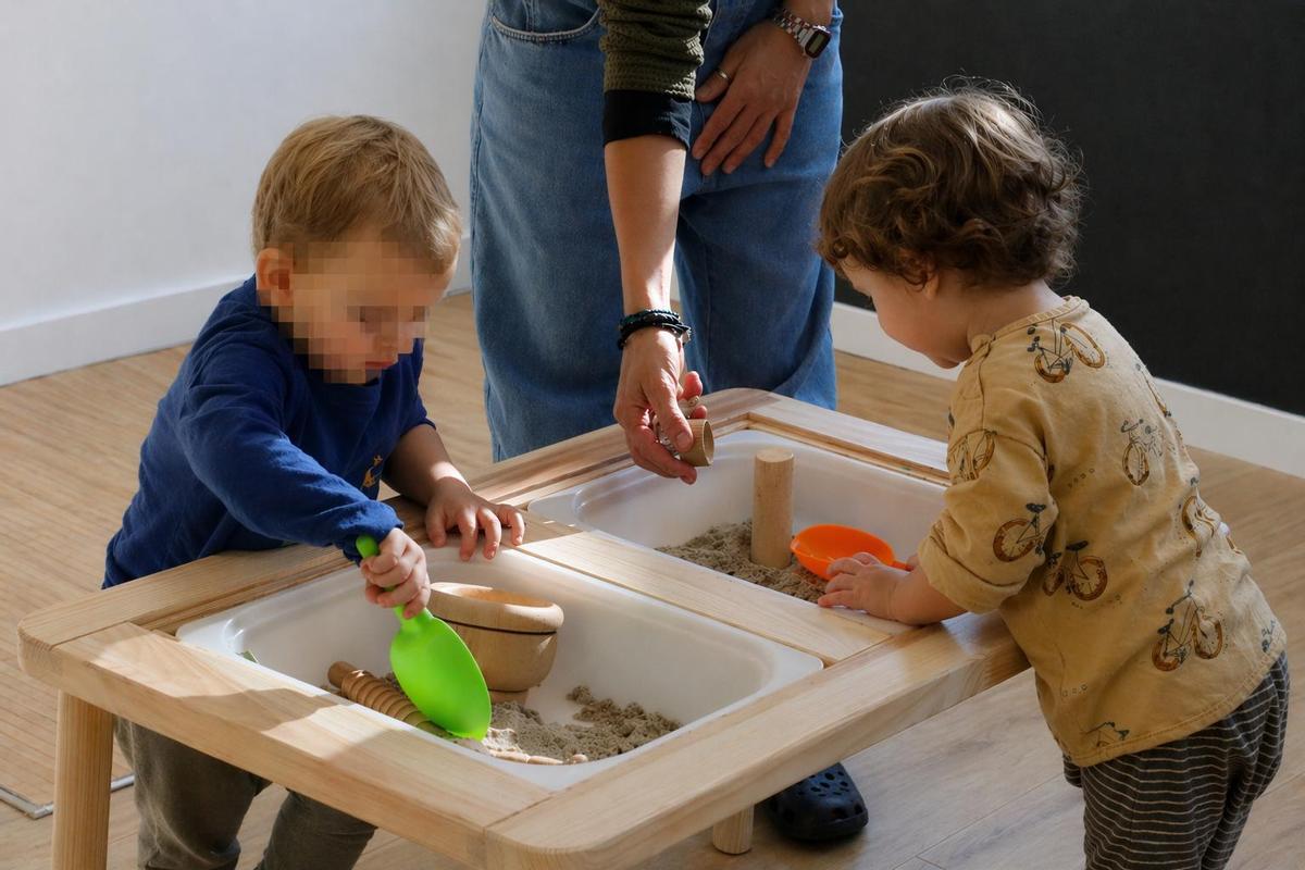 Dos nens duna llar dinfants rural experimentant amb diversos materials, en una imatge darxiu.