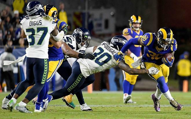 El corredor Todd Gurley # 30 de los Rams de Los Ángeles lleva la pelota contra la defensa del fuerte seguridad Bradley McDougald # 30 de los Seattle Seahawks durante el juego en el Coliseo Memorial de Los Ángeles en Los Ángeles, California.