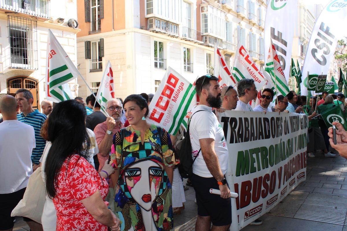 La coordinadora provincial de IU Málaga y portavoz adjunta del grupo municipal de Con Málaga, Toni Morillas, junto a trabajadores del metro.