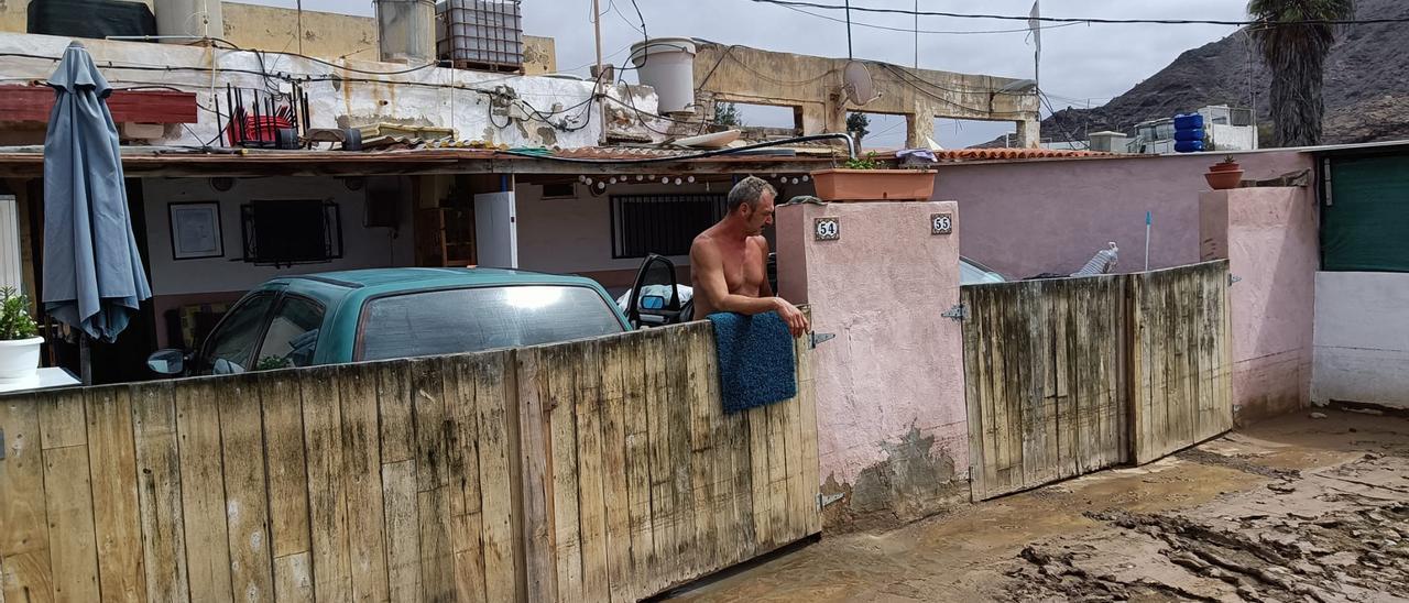 Víctor Brito, a las puertas de su casa, señala la marca que muestra la altura que tomó el agua.