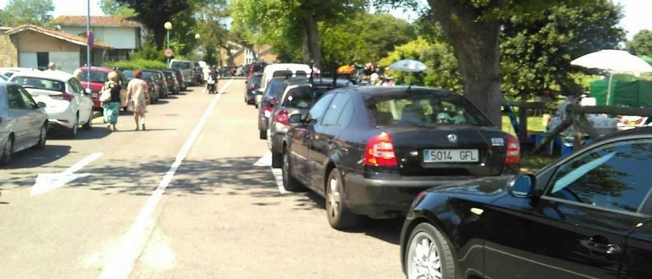 Numerosos vehículos aparcados sobre línea amarilla, el pasado domingo en la ciudad residencial de Perlora.