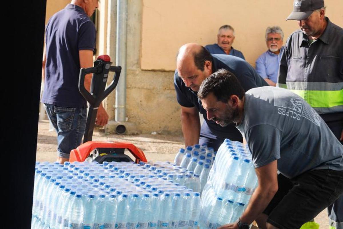 Voluntarios almacenan botellas de agua en el albergue para su reparto entre los afectados.
