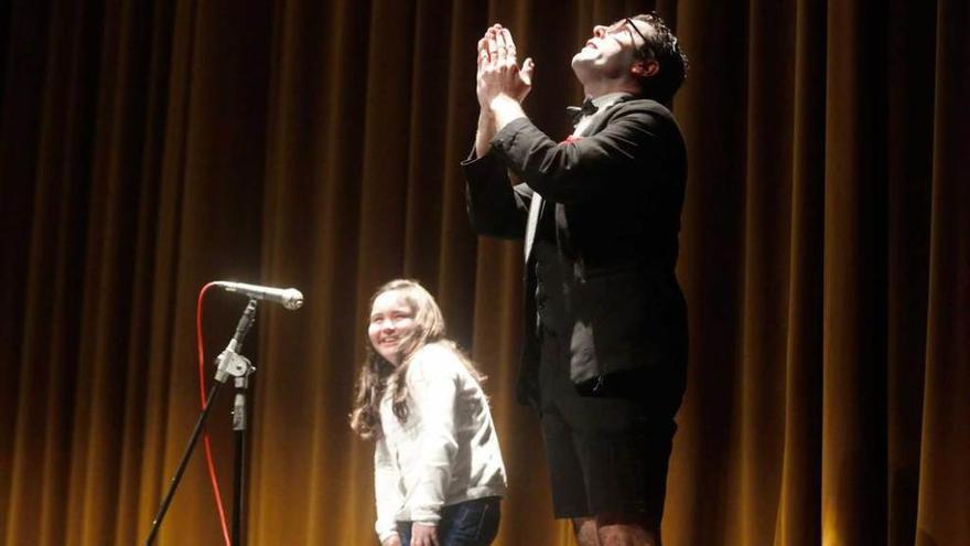 El mago Adrián Conde, durante el espectáculo, junto a una de las niñas del público.