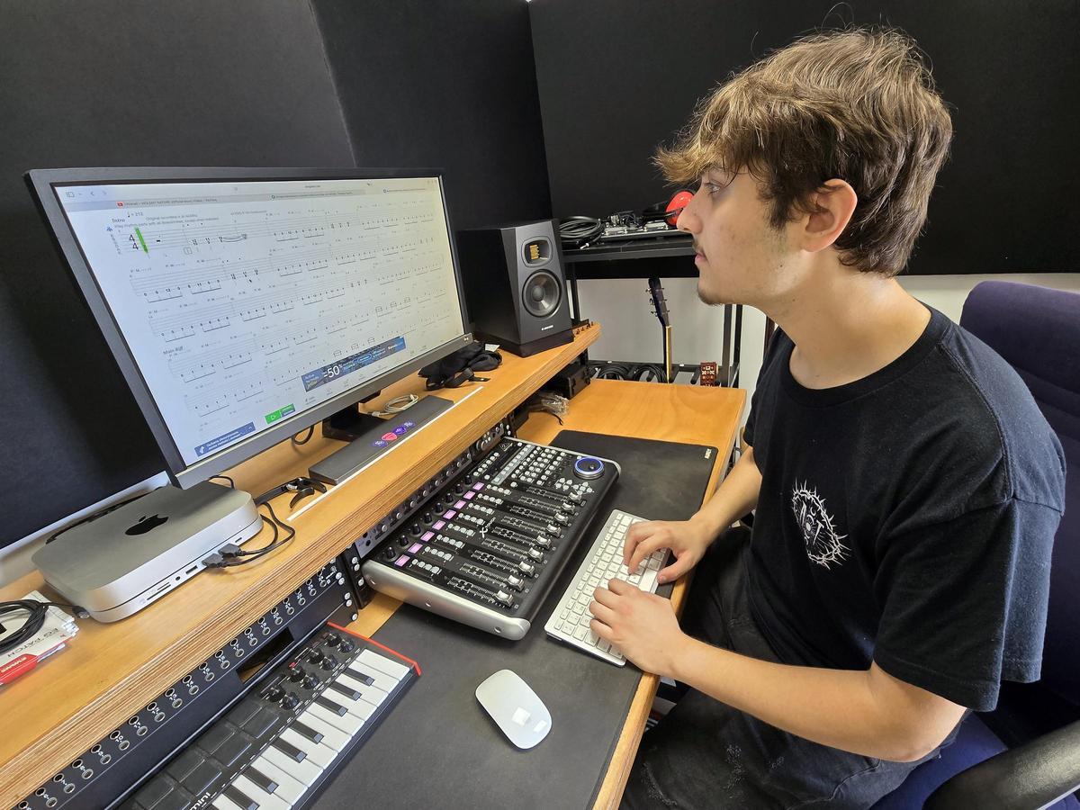 Mateo Gallego leyendo partituras de batería en su estudio.
