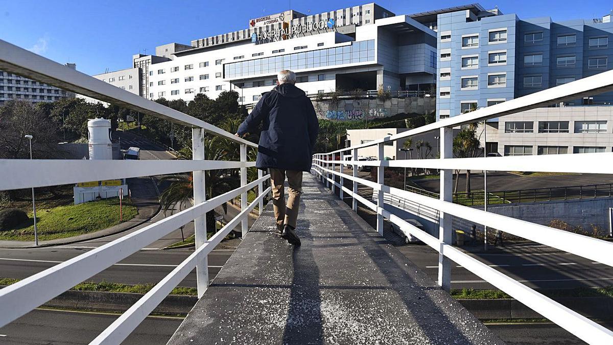 Un hombre camina por la pasarela peatonal de acceso al Hospital Universitario de A Coruña.   | // C. PARDELLAS