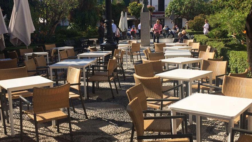 Turistas visitan y almuerzan en la plaza de Los Naranjos.