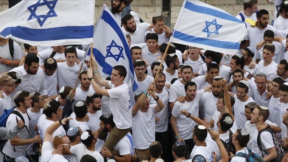 Manifestantes israelís celebran la aprobación de la ley en el Parlamento.