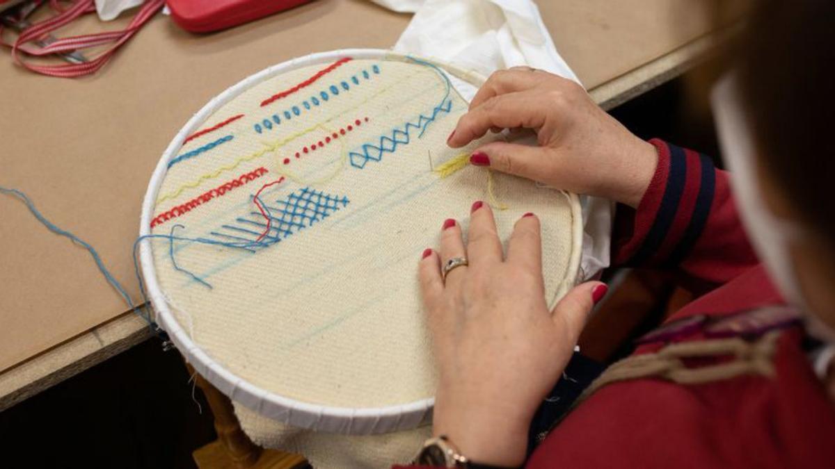 Una mujer hace una muestra de bordado antiguo. | Emilio Fraile