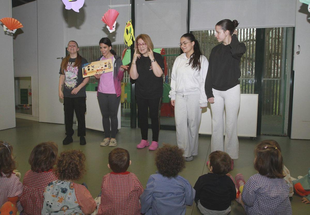 Niños y niñas atienden a las profesionales durante la lectura animada de un cuento. | IÑAKI OSORIO