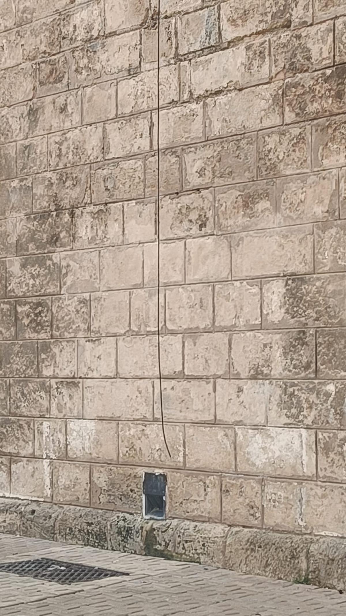 El cable cortado se descuelga junto al muro