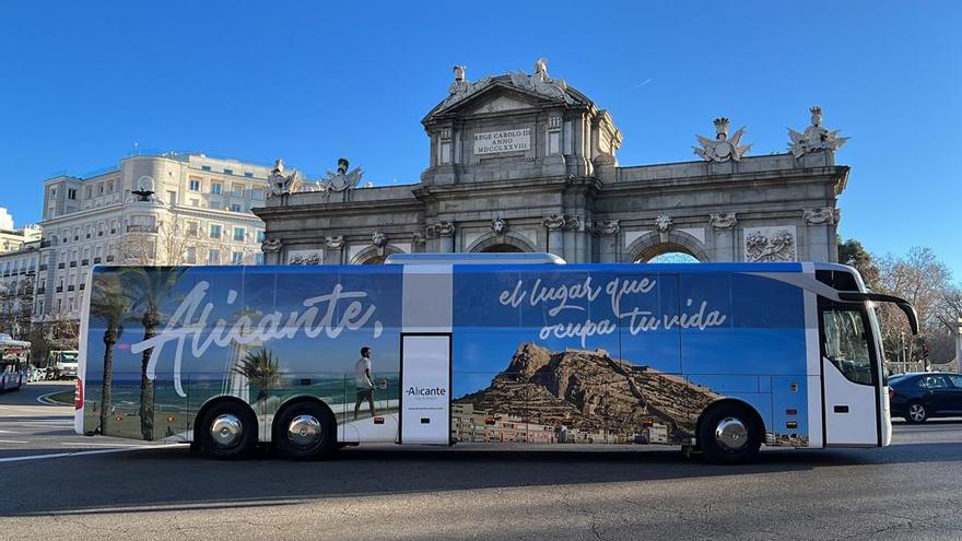 Autobús pasando por la Puerta de Alcalá con el lema &quot;Alicante, el lugar que ocupa tu vida&quot;