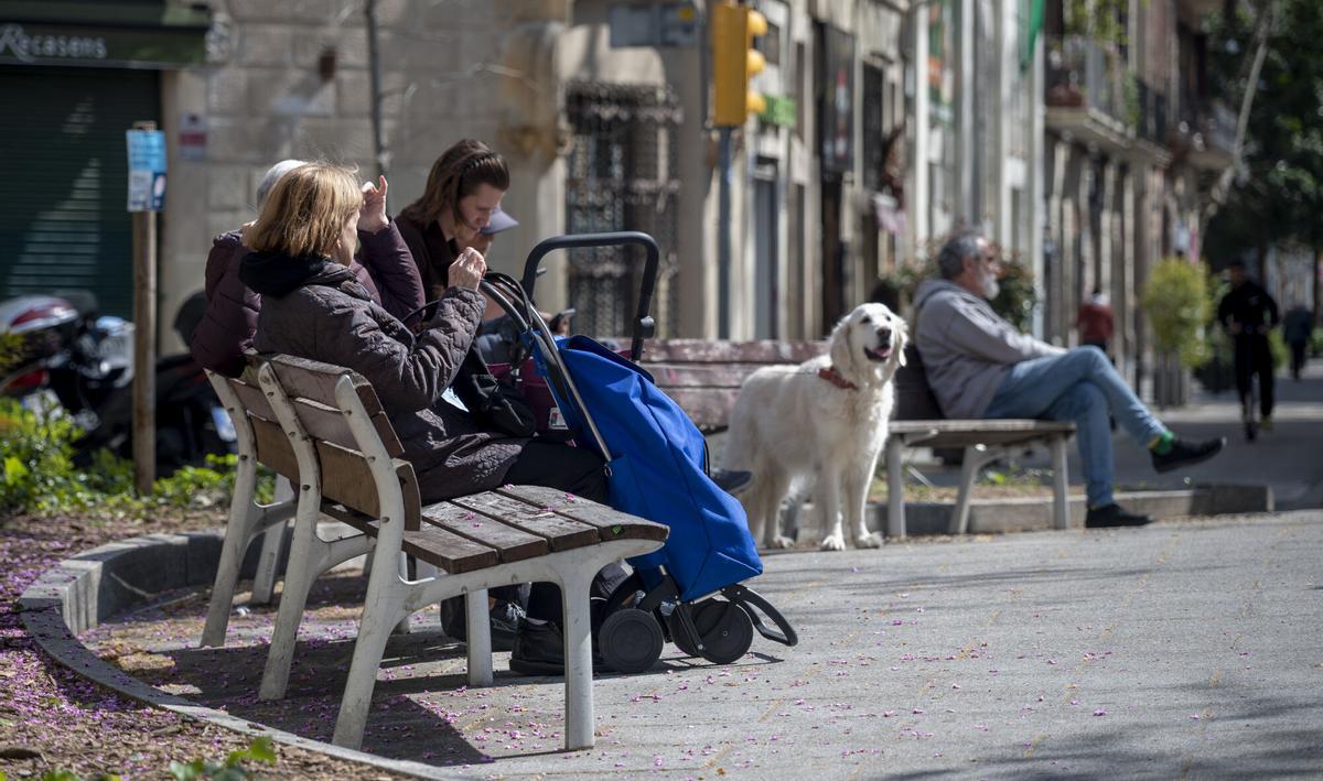Vecinos sentados en un banco en la Rambla del Poblenou