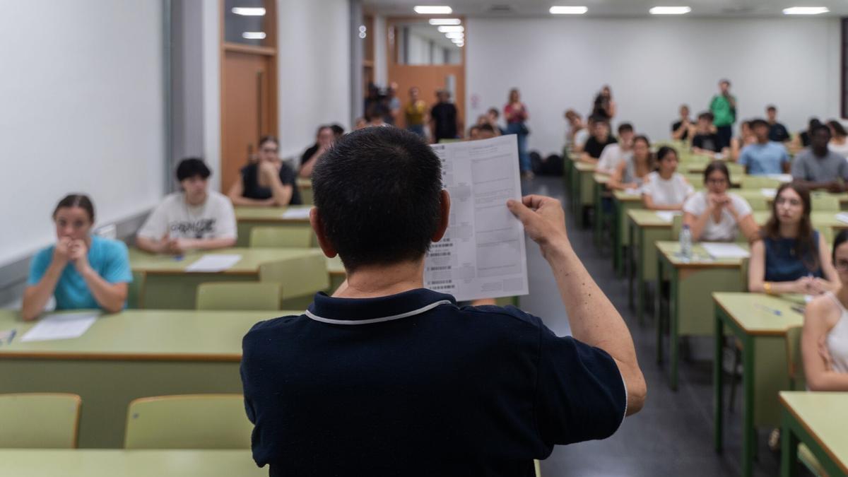 Un profesor muestra un examen a sus alumnos.
