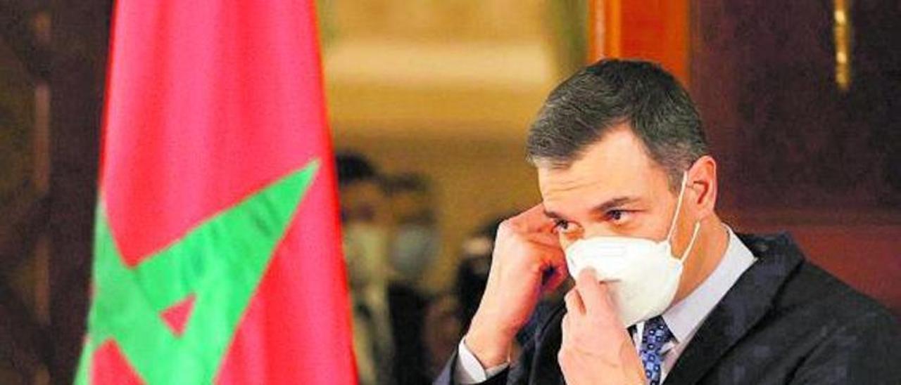 Pedro Sánchez junto a una bandera de Marruecos en su reciente visita institucional a Rabat.