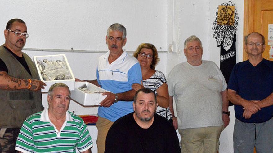 Curro López (izq.) con pescado congelado y un grupo de voluntarios de la asociación ayer.