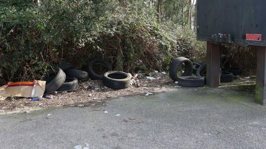 Neumáticos, basura y maleza en el estacionamiento de la playa de O Terrón, en Vilanova de Arousa.