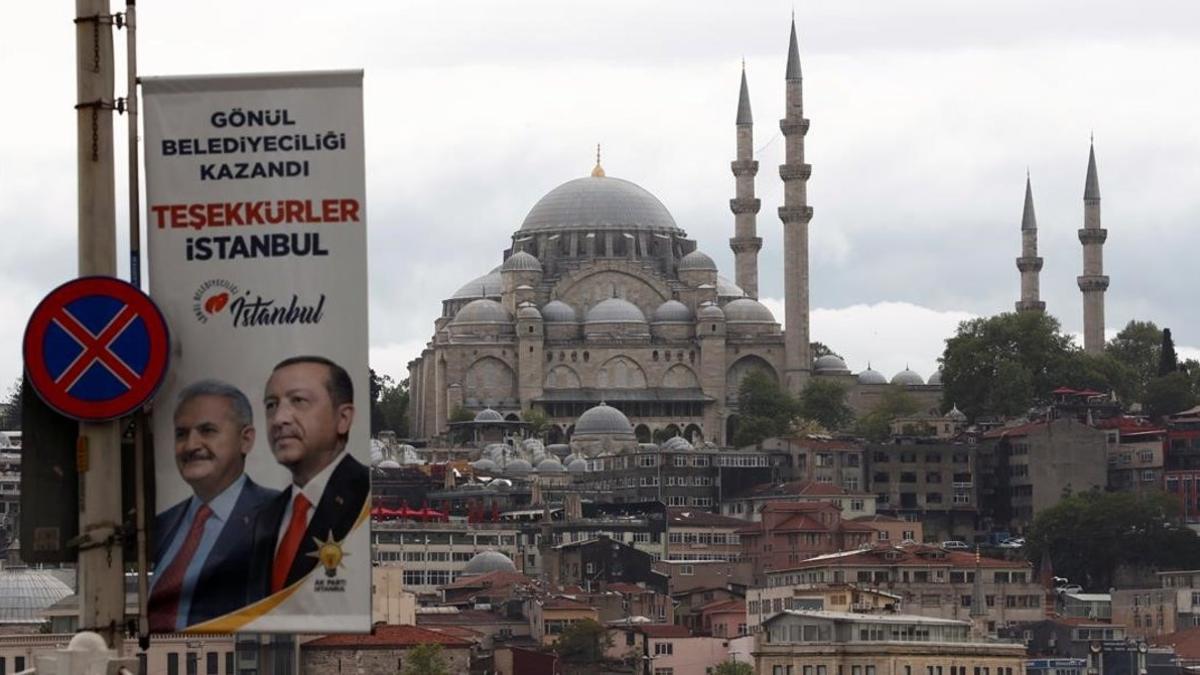 Pancarta electoral con las fotos del presidente turco, Recep Tayyip Erdogan, y del candidato a la alcaldía del Partido AK Binali Yildirim en los alrededores del puente de Galata, en Estambul.