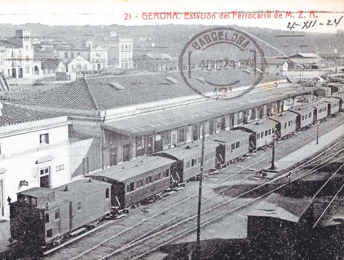 Una postal antiga que mostra un comboi aturat a l'antiga estació de ferrocarril de Girona.