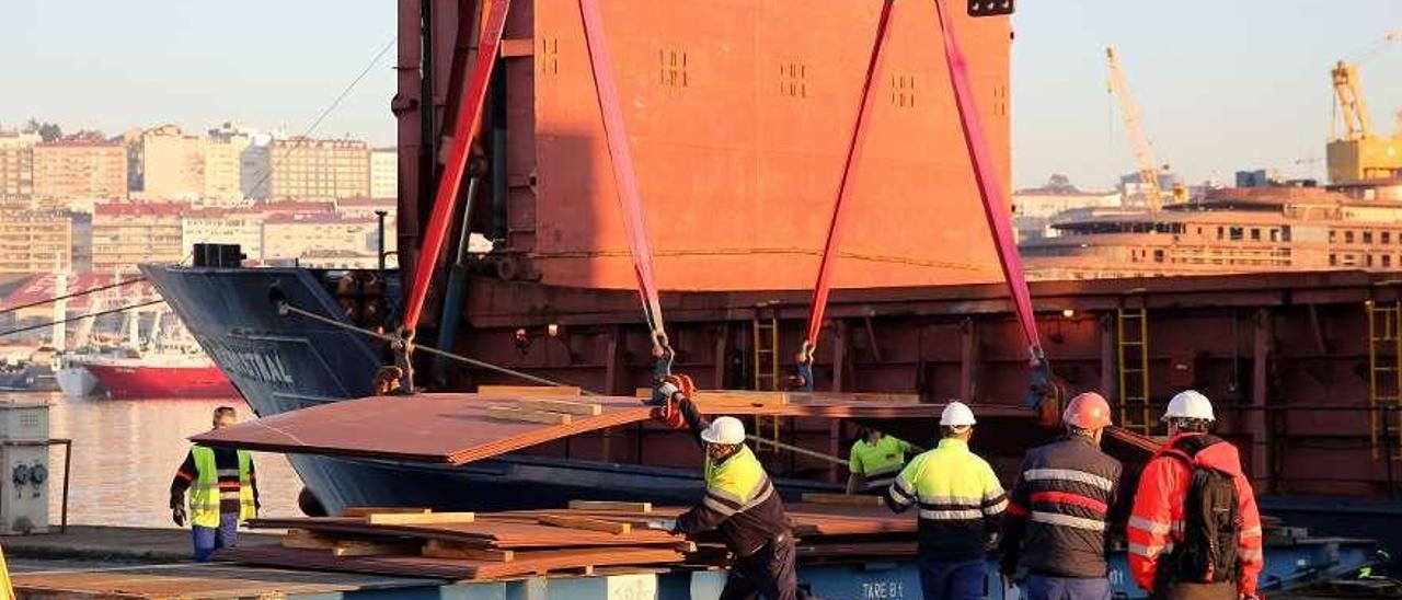 Operarios trabajando en la descarga de chapa, ayer en el muelle de Reparaciones. // Marta G. Brea