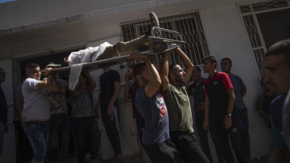 Palestinos transportan el cuerpo de un hombre muerto durante los combates con las fuerzas israelís en la ciudad de Gaza.