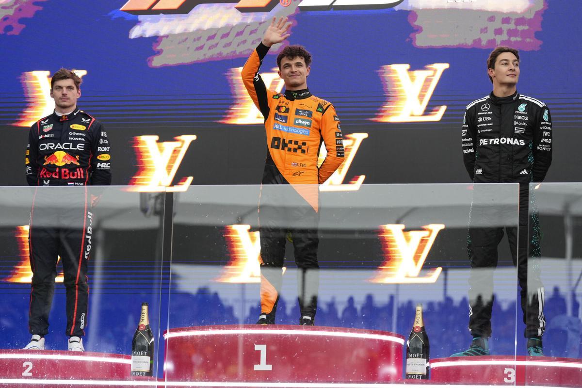 Race winner McLaren driver Lando Norris of Britain, centre, stands with second placed Max Verstappen, left, of the Netherlands and third placed Mercedes driver George Russell, right, of Britain on the podium following the Australian Formula One Grand Prix at Albert Park, in Melbourne, Australia, Sunday, March 16, 2025. (AP Photo/Asanka Brendon Ratnayake)