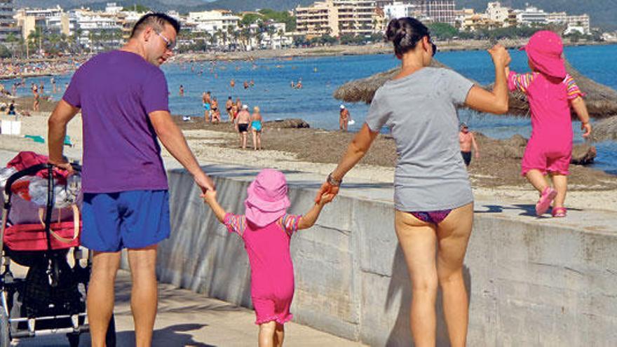 Una familia de turistas paseando esta semana en Cala Millor. A finales de este mes habrán cerrado la gran mayoría de hoteles. Apenas media docena de establecimientos turísticos de la bahía permanecen abiertos todo el año.