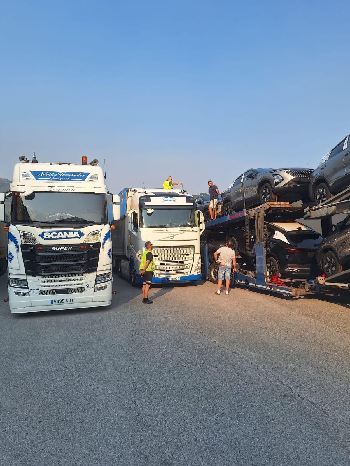 Un camión portavehículos, junto con los camioneros dañados