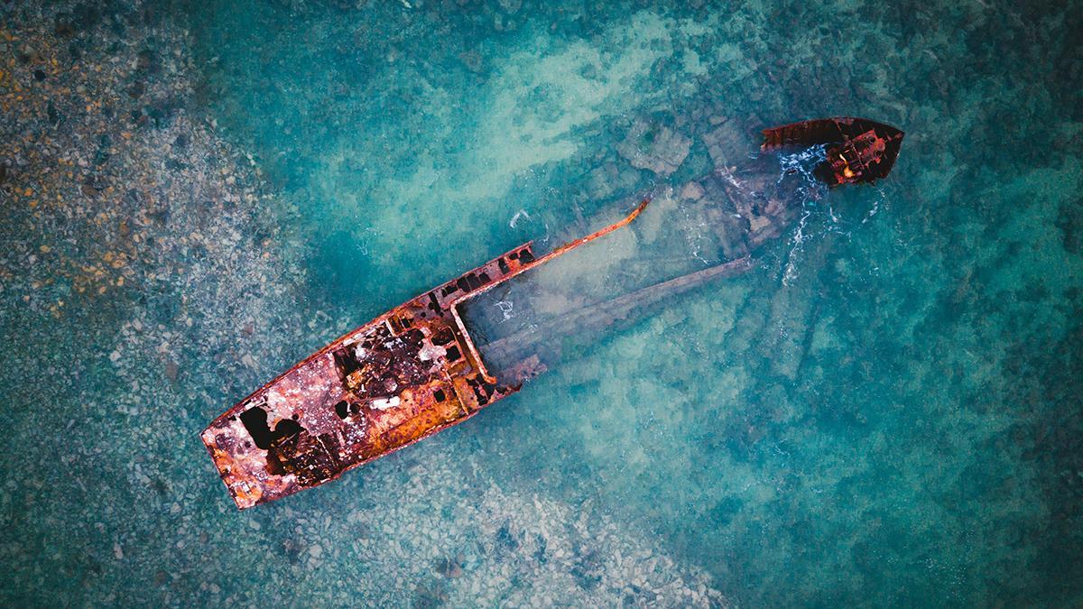 Restos de un barco sobre aguas transparentes, una imagen que resume el carácter atlántico y volcánico de Santo Tomé y Príncipe.