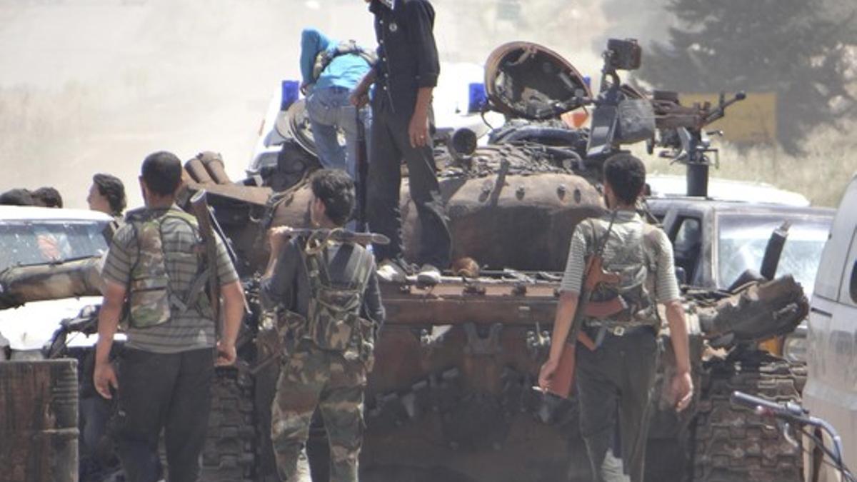 Rebeldes sirios inspeccionan un tanque de las tropas de Asad, en Nayrab.
