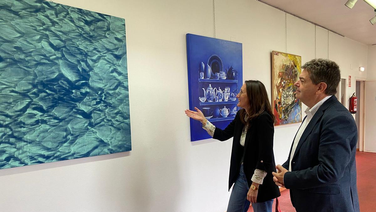 El alcalde de San Martín del Rey Aurelio, José Ramón Martín Ardines, y la concejala de Cultura, Cintia Ordóñez, contemplan la obra ganadora del concurso de pintura Nicanor Piñole