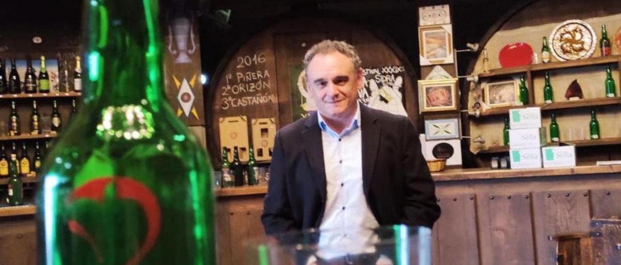 Juan Cañal, tras una botella y un vaso conmemorativos del 25.º aniversario. |  “Spot Gonzalo”