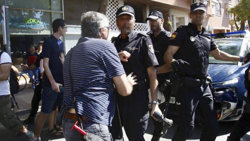 Carlos (de espaldas), frente a un agente de la Policía, en una de las mañanas en las que se vivieron escenas de tensión en la zona de las vías.