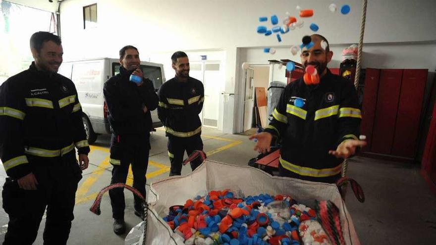 Los bomberos ayudan con tapones de plástico a un niño enfermo de Tomiño. // I. Abella