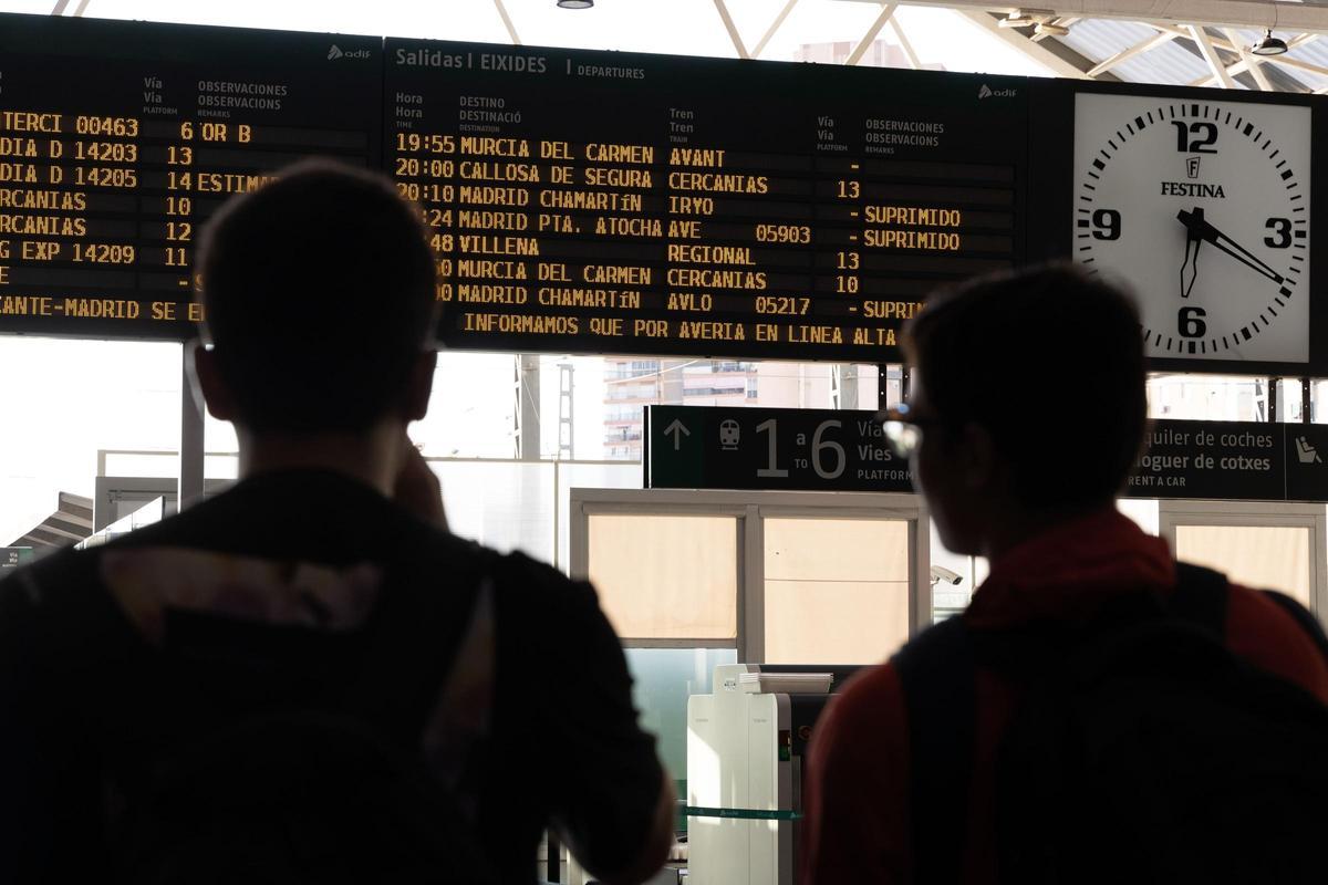 Dos pasajeros esperan para marcharse en la estación de Alicante.
