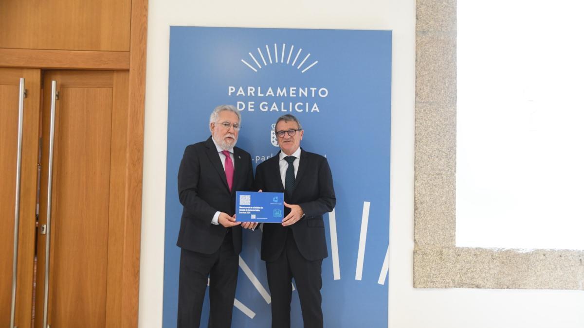 El conselleiro maior del Consello e Contas, Juan Carlos Aladro, entrega los informes al presidente del Parlamento.