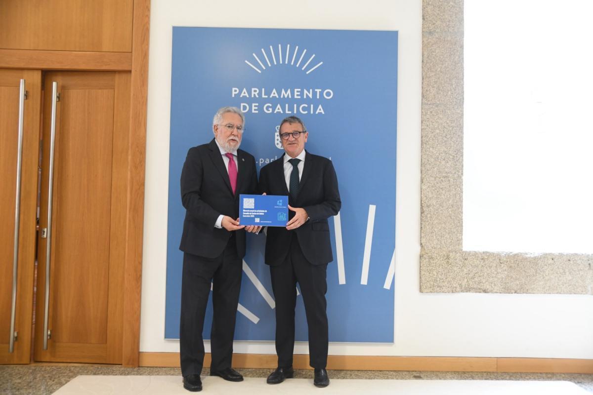 El conselleiro maior del Consello de Contas, Juan Carlos Aladro, entrega los informes al presidente del Parlamento.