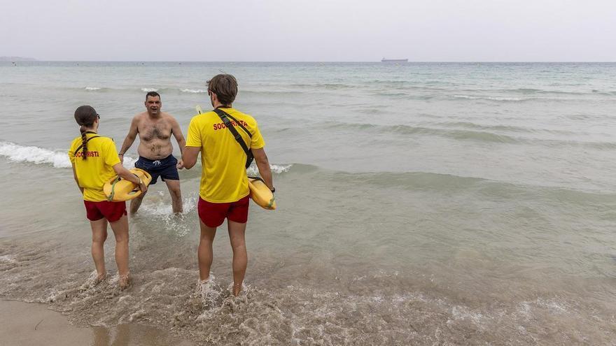 Sin sombrillas y solo los pies en el agua del Postiguet